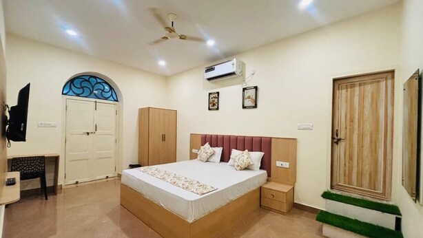 A bedroom with a bed, wardrobe, bedside table, and a ceiling fan. - SAH HAVELI 400m WALK TO KASHI VISHWANATH (Varanasi)