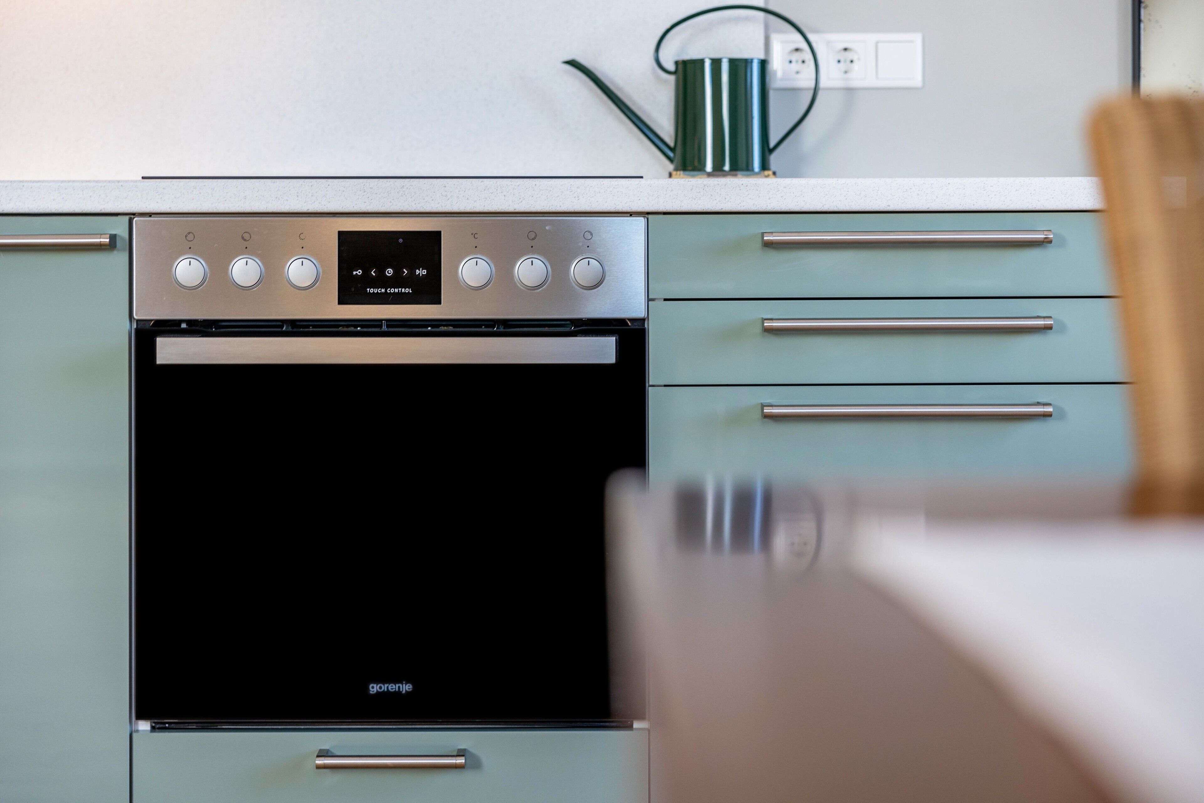Una cucina moderna con forno integrato, maniglie in acciaio inossidabile e pannello di controllo touch.