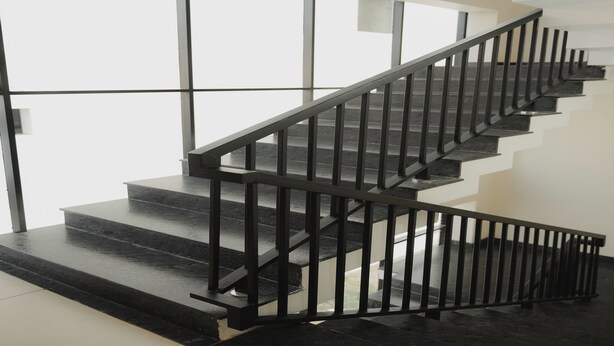 A modern staircase with black railings and a geometric wall design. - Hotel Calicut Beach Annex (Kozhikode)