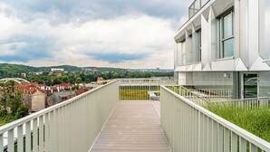 A modern building with a long, narrow balcony overlooking a cityscape. - RentPlanet - Apartament przy Stoczni (Gdańsk)