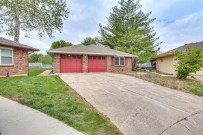 Une maison d’habitation avec un garage rouge, une allée et une pelouse.