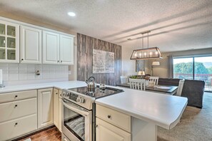 A modern kitchen with white cabinetry, a built-in oven, and a large island. - 2-Unit Escape - Pointe Royale Golf Resort, Pools (Branson)