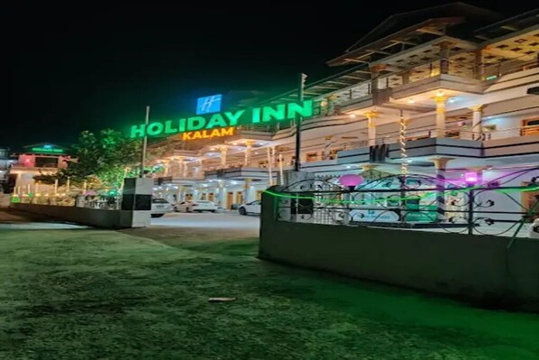A multi-story building with a sign reading 'Holiday Inn Kalam.'