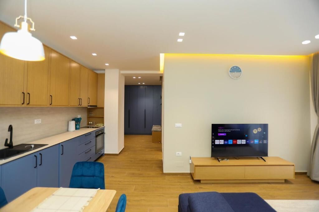 A modern living room with a TV, sofa, and dining area.