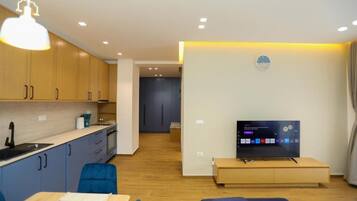 A modern living room with a TV, sofa, and dining area.