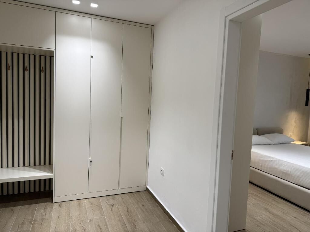A bedroom with a bed, a wardrobe, and a door leading to another room.