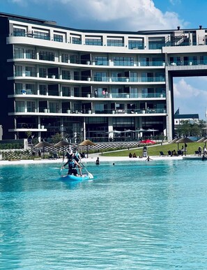 A multi-story hotel with balconies, a pool area, and outdoor seating. - Mawuya-Tigashire Munyaka Executive Apartments (Midrand)