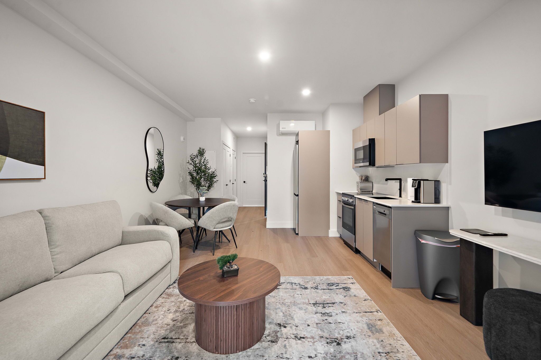 A modern living room with a sofa, coffee table, and dining area.