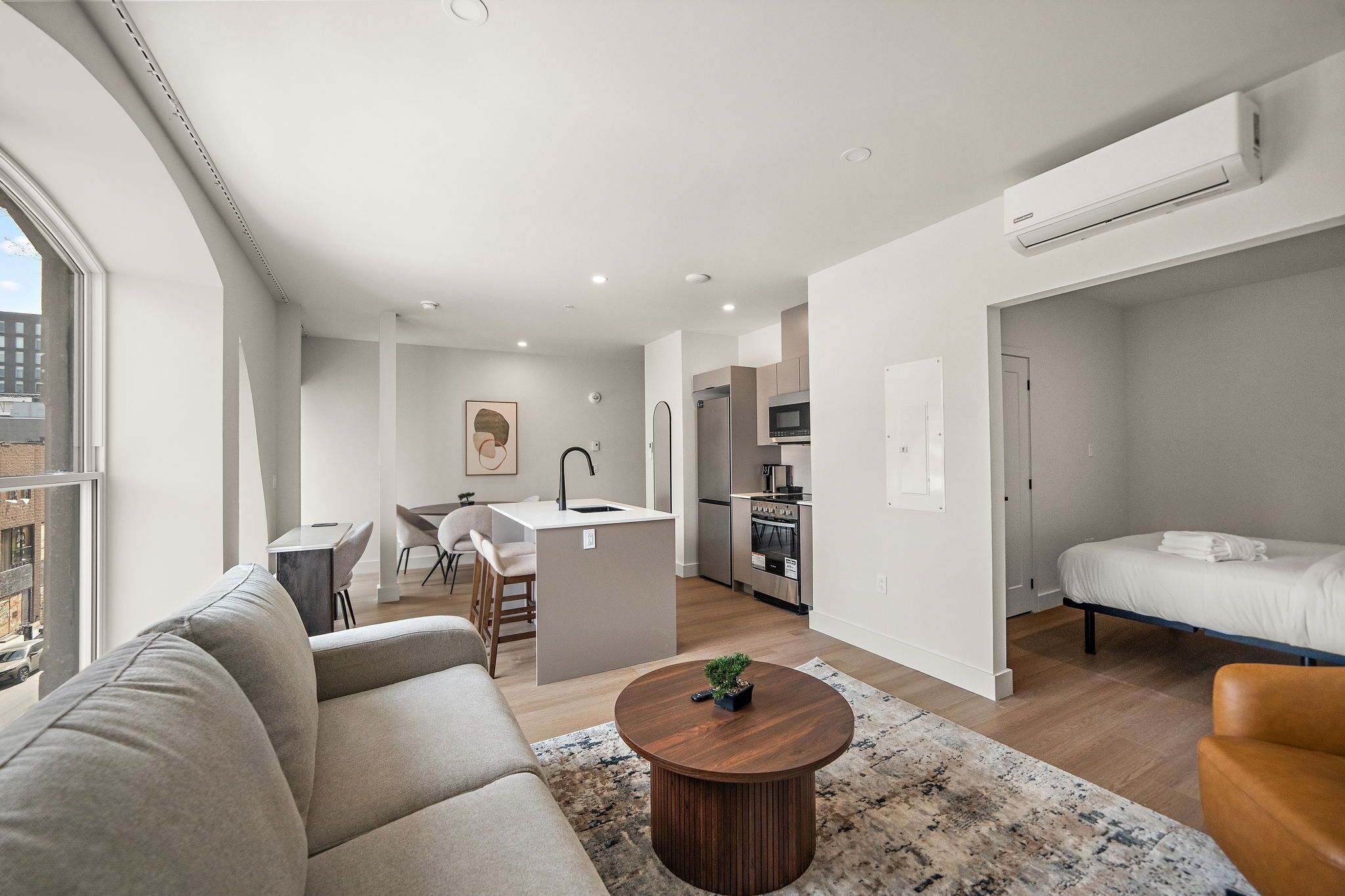 A modern apartment with a living room, kitchen, and bedroom.