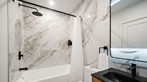 A modern bathroom with a shower, toilet, and sink. - Nomade Saint Paul (Montréal)
