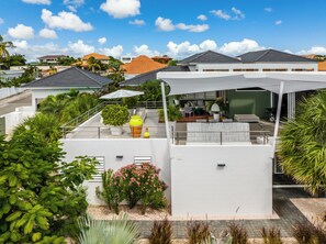 A modern residential building with a rooftop patio, outdoor seating, and lush greenery. - Luxury 5 star Villa with private pool 600 m from Jan Thiel Beach (Jan Thiel)