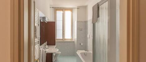 A bathroom with a toilet, sink, and bathtub.