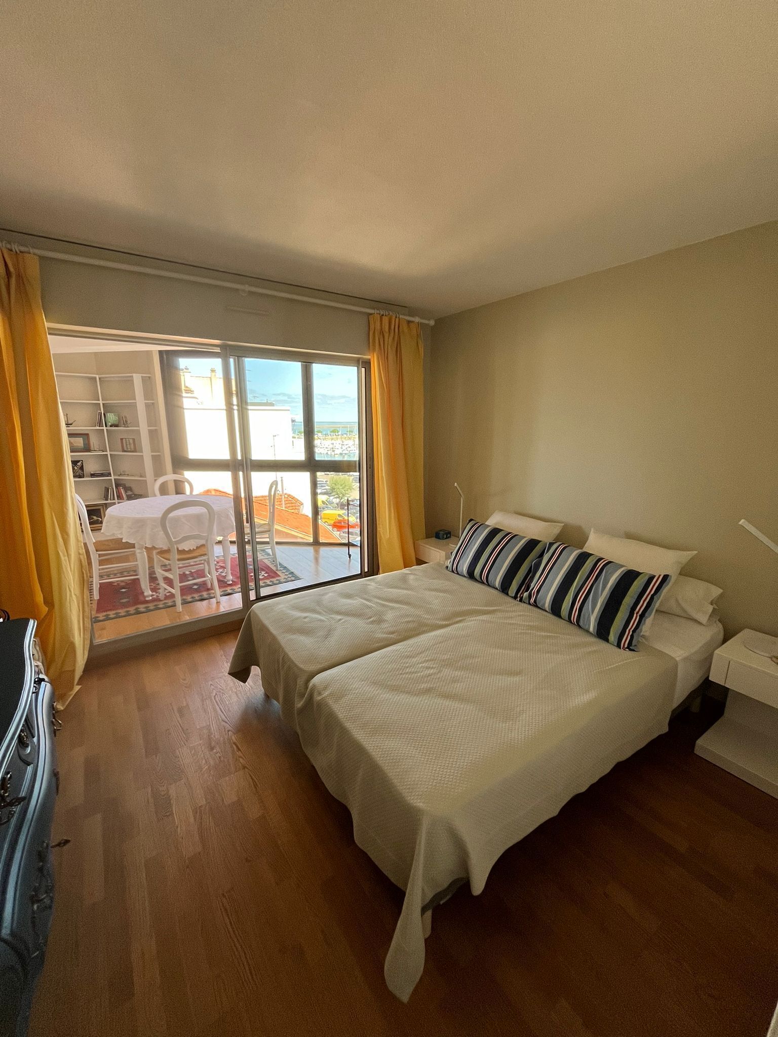 Una camera d'albergo con un letto, una scrivania, una sedia e una vista attraverso una grande finestra.
