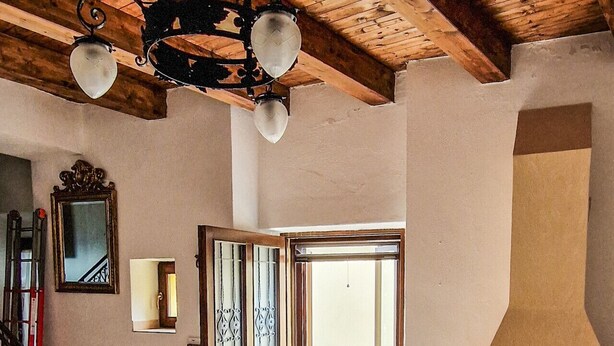 A spacious interior with a wooden ceiling, a fireplace, a staircase, and a door leading outside. - Liana's home in Letino (Letino)