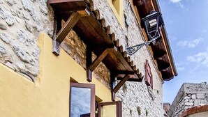 A stone building with a yellow facade, a wooden door, and a small window. - Liana's home in Letino (Letino)