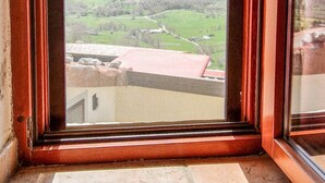 A window with a view of a mountainous landscape and a building with a red roof. - Liana's home in Letino (Letino)