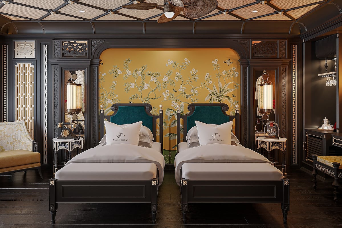 A room with two beds, a large mirror, and a decorative wall with floral patterns.