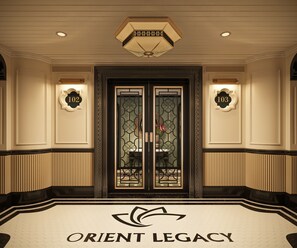 Entrada de hotel con puertas dobles, placas numeradas y un logotipo en el suelo.