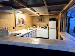 A kitchen with wooden cabinets, a microwave, and a refrigerator.