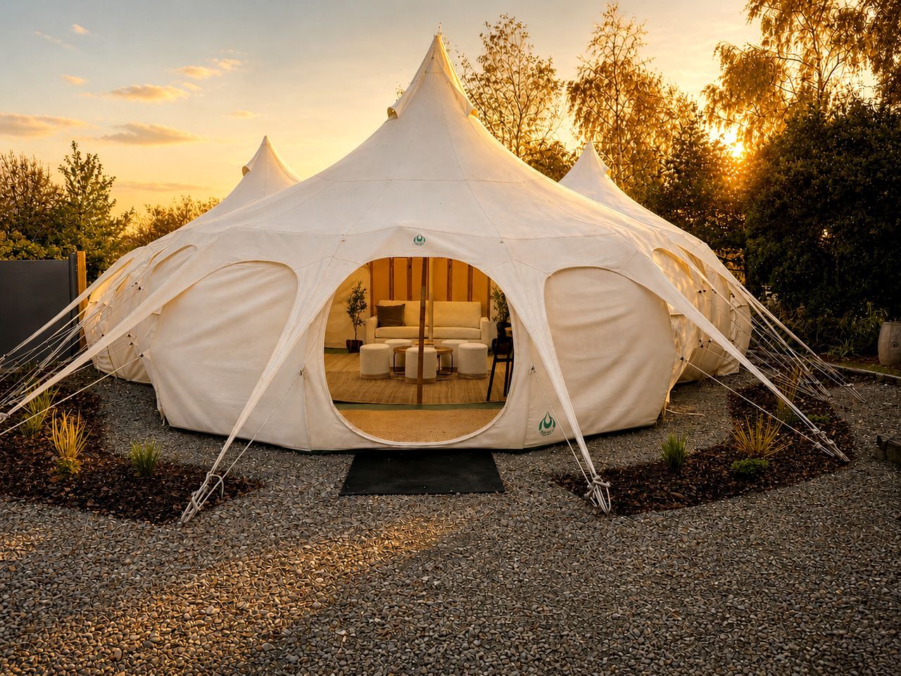 A white tent with a circular entrance, a sofa, and a coffee table inside.