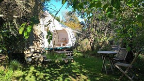 A tent with a table and chairs in a garden.