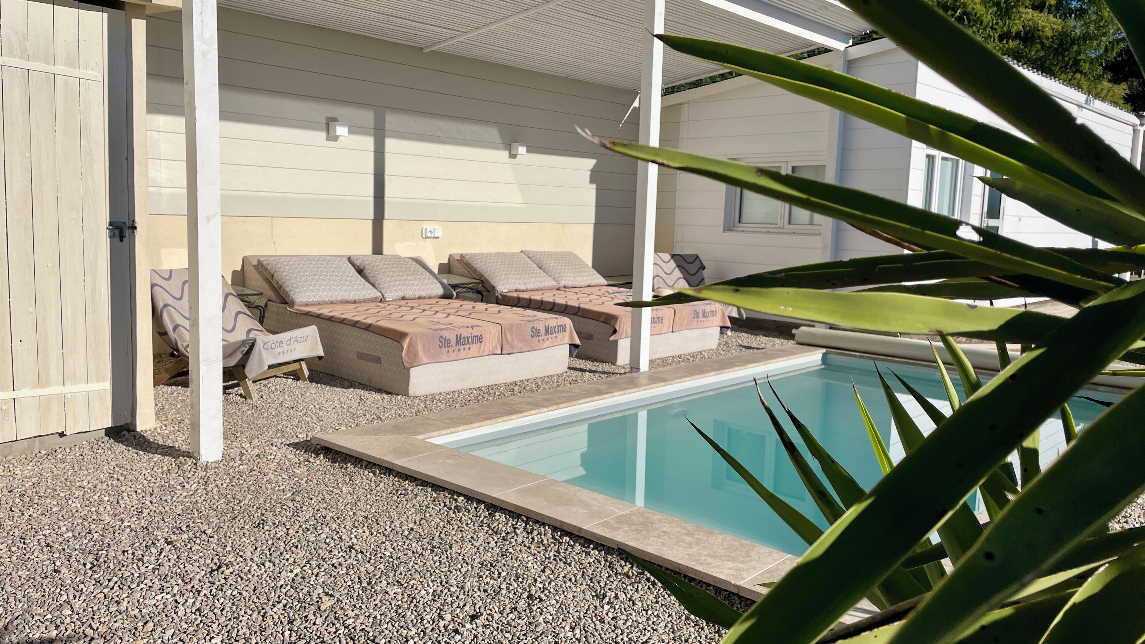 Un espace aménagé au bord de la piscine, avec des chaises longues et une piscine.