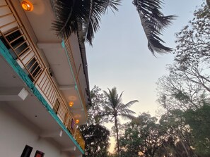 Ein mehrgeschossiges Gebäude mit Balkonen, blauem Himmel und umliegenden Bäumen.