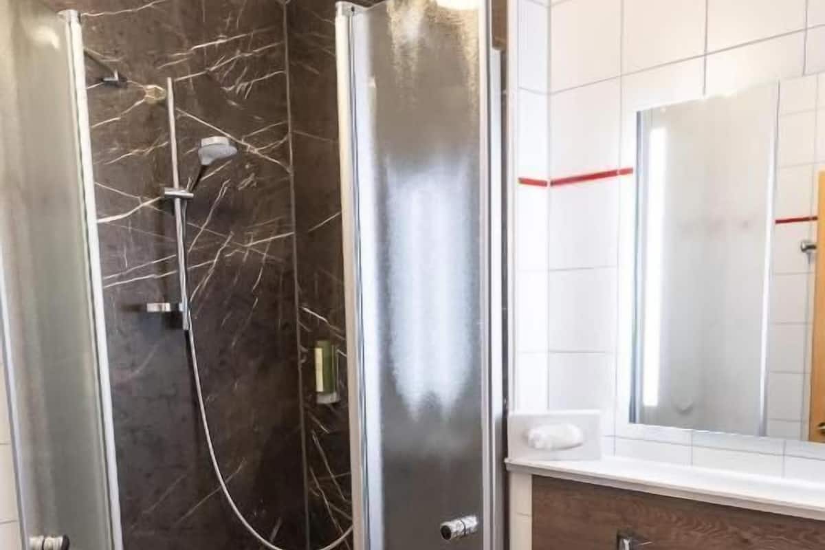 Quarto solteiro clássico, sacada, vista para o jardim | Banheiro | Chuveiro, secador de cabelo, chinelos, toalhas de banho