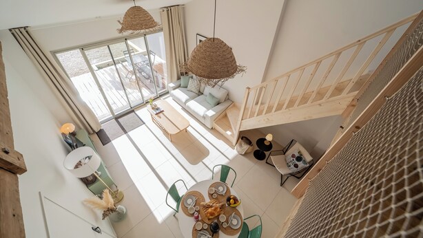 Un intérieur moderne comprenant un coin repas, un canapé et un escalier.