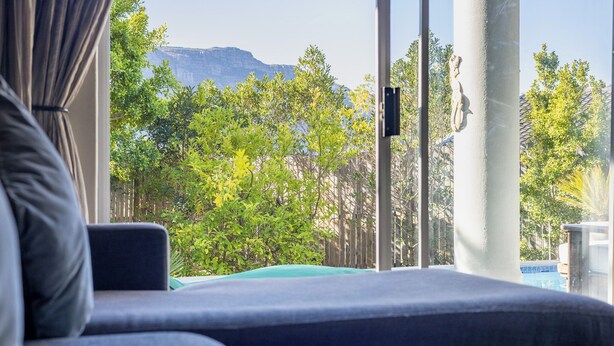Une chambre avec vue sur une montagne, une piscine et une statue.
