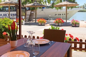 Une table dressée pour le dîner, avec vue sur un bateau et l’eau.