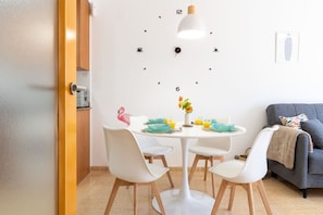 Un coin repas avec une table ronde, des chaises, une horloge et un canapé.