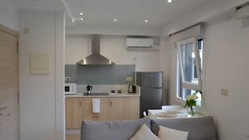 Una cocina moderna con una campana extractora de acero inoxidable, un refrigerador y un microondas.