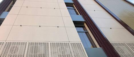 A building with a sign reading 'HOTEL THE GALAXY' and a patterned facade.