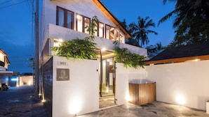 Eine moderne Villa mit zweistöckiger Bauweise, einem verschlossenen Eingangsbereich und einer gut beleuchteten Außenfassade.