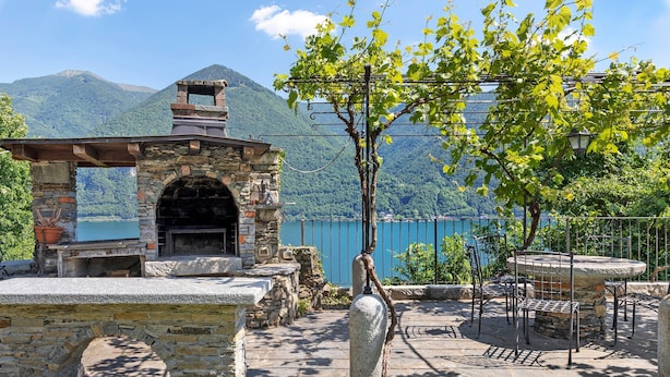 A stone outdoor kitchen with a view of a lake and mountains. - Villa 'Porlezza Lake View' with Lake View, Air Conditioning, Private Pool, Ultra-Fast Wi-Fi (Cima)