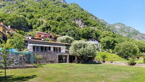 A villa with a stone facade, a covered patio, and a view of a mountainous landscape. - Villa 'Porlezza Lake View' with Lake View, Air Conditioning, Private Pool, Ultra-Fast Wi-Fi (Cima)