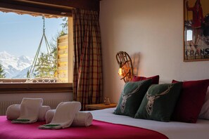 Una habitación de hotel con una cama, toallas, una lámpara, una cortina escocesa y un cartel en la pared.