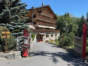 Una cabaña de madera con varios balcones, una zona de recepción y un telesilla.