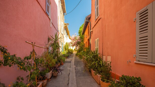 A narrow alleyway with potted plants and buildings on either side. - 'O'soleil' Apartment with Wi-Fi and Air Conditioning (Fréjus)