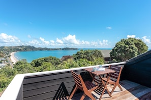 Outdoor dining - The Point - Onetangi. Luxury & Ocean Views - The Point is a private, light-filled home above Onetangi Beach with wide north-facing sea views. Surrounded by native bush, it offers a peaceful, secluded stay. Open-plan living includes a well-equipped ki (Waiheke Island)