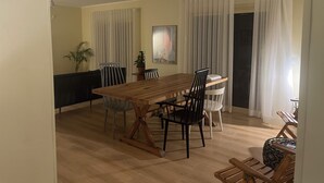 A dining area with a wooden table, chairs, a ceiling fan, and a view through a doorway. - Spacious 3-bedroom apartment in the heart of Sheikh Zayed with Garden view (Giza Governorate)