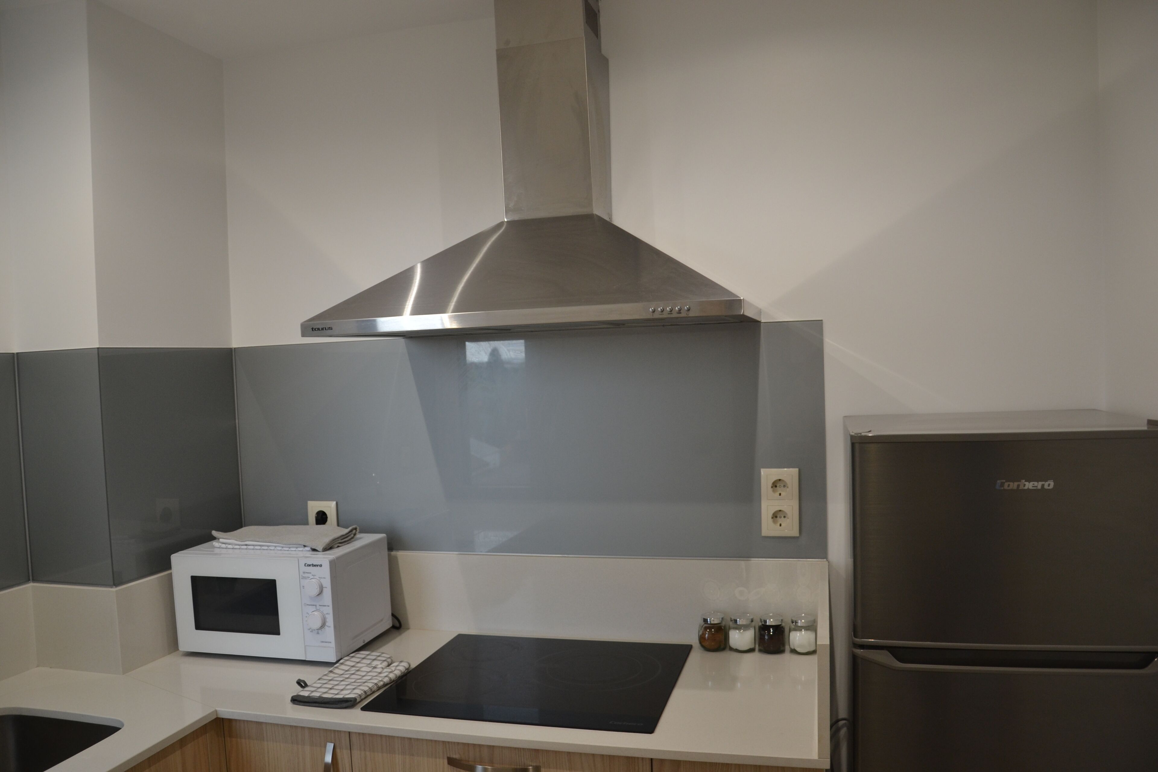 Una cocina con microondas, estufa y refrigerador.