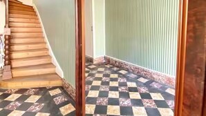 Uma escadaria com degraus de madeira e piso xadrez.
