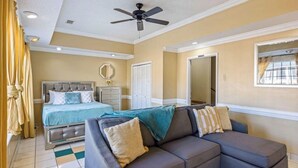 A bedroom with a bed, a sofa, a ceiling fan, a window, and a door. - Master’s Magic Retreat-2 Bedrooms-Augusta Regional Airport-Feels Like Home (Augusta)