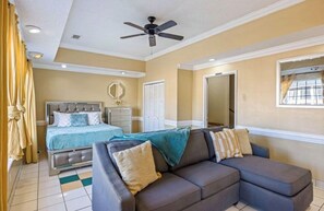 A bedroom with a bed, a sofa, a ceiling fan, a window, and a door. - Master’s Magic Retreat-2 Bedrooms-Augusta Regional Airport-Feels Like Home (Augusta)