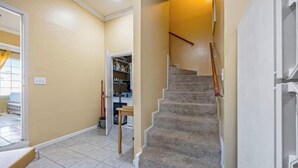 A hallway with a carpeted staircase, a door leading to a room with a bed, and a closet with shelves. - Master’s Magic Retreat-2 Bedrooms-Augusta Regional Airport-Feels Like Home (Augusta)