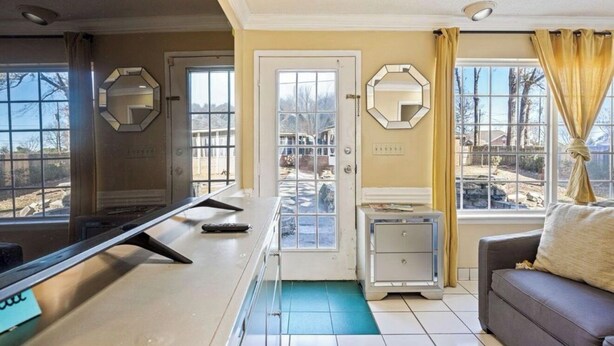 A room with a desk, a couch, a door with a window, and a mirror on the wall. - Master’s Magic Retreat-2 Bedrooms-Augusta Regional Airport-Feels Like Home (Augusta)