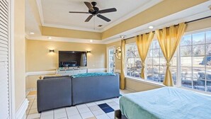 A bedroom with a bed, a sofa, a TV, and a window with curtains. - Master’s Magic Retreat-2 Bedrooms-Augusta Regional Airport-Feels Like Home (Augusta)
