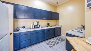 A compact kitchen with dark blue cabinets, a microwave, a toaster, and a small countertop area. - Master’s Magic Retreat-2 Bedrooms-Augusta Regional Airport-Feels Like Home (Augusta)